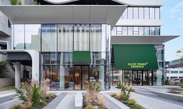 Exterior view of an Olive Young store on a vibrant street in Seoul, featuring its modern storefront and product displays.